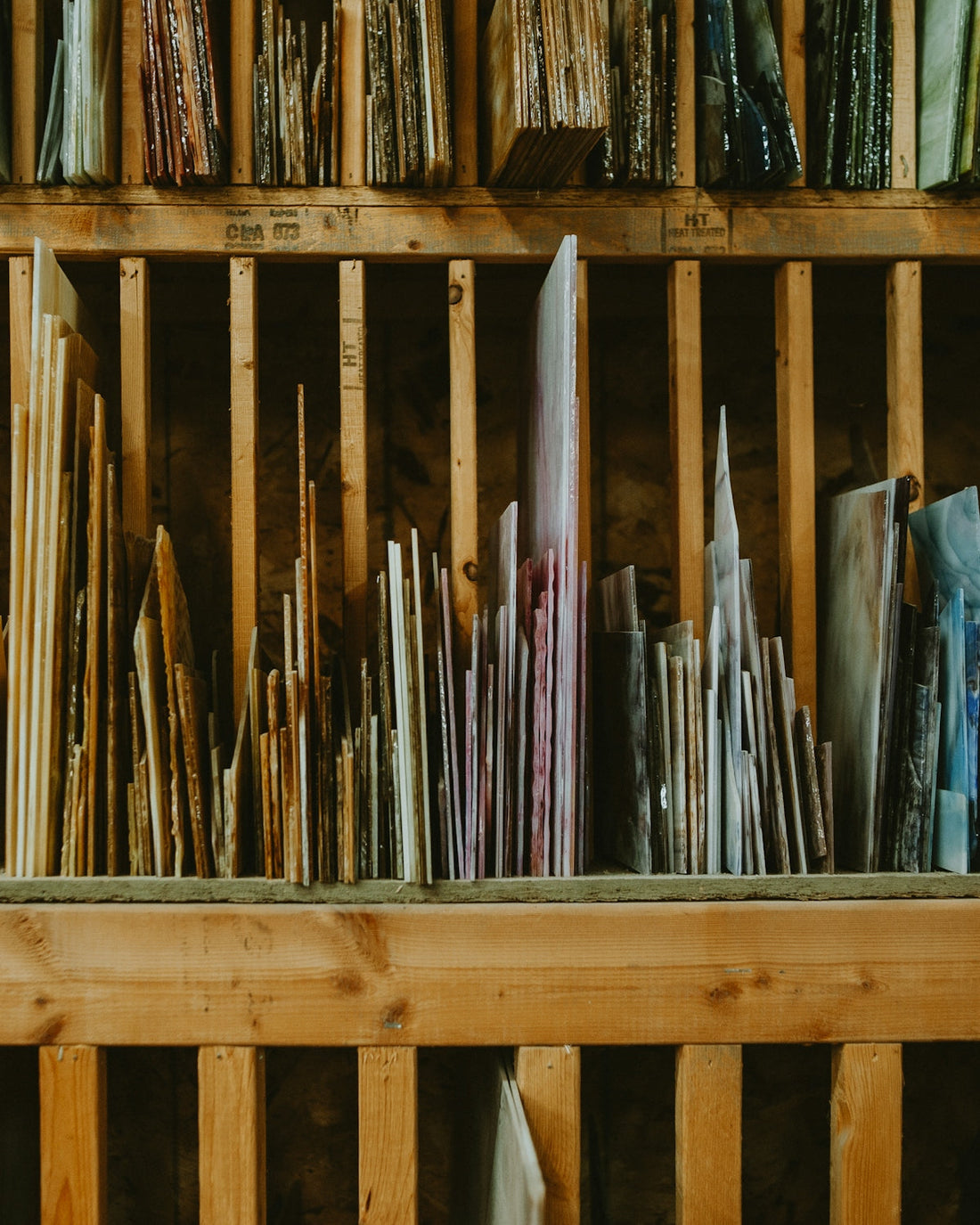 a wooden shelf filled with lots of different types of umbrellas