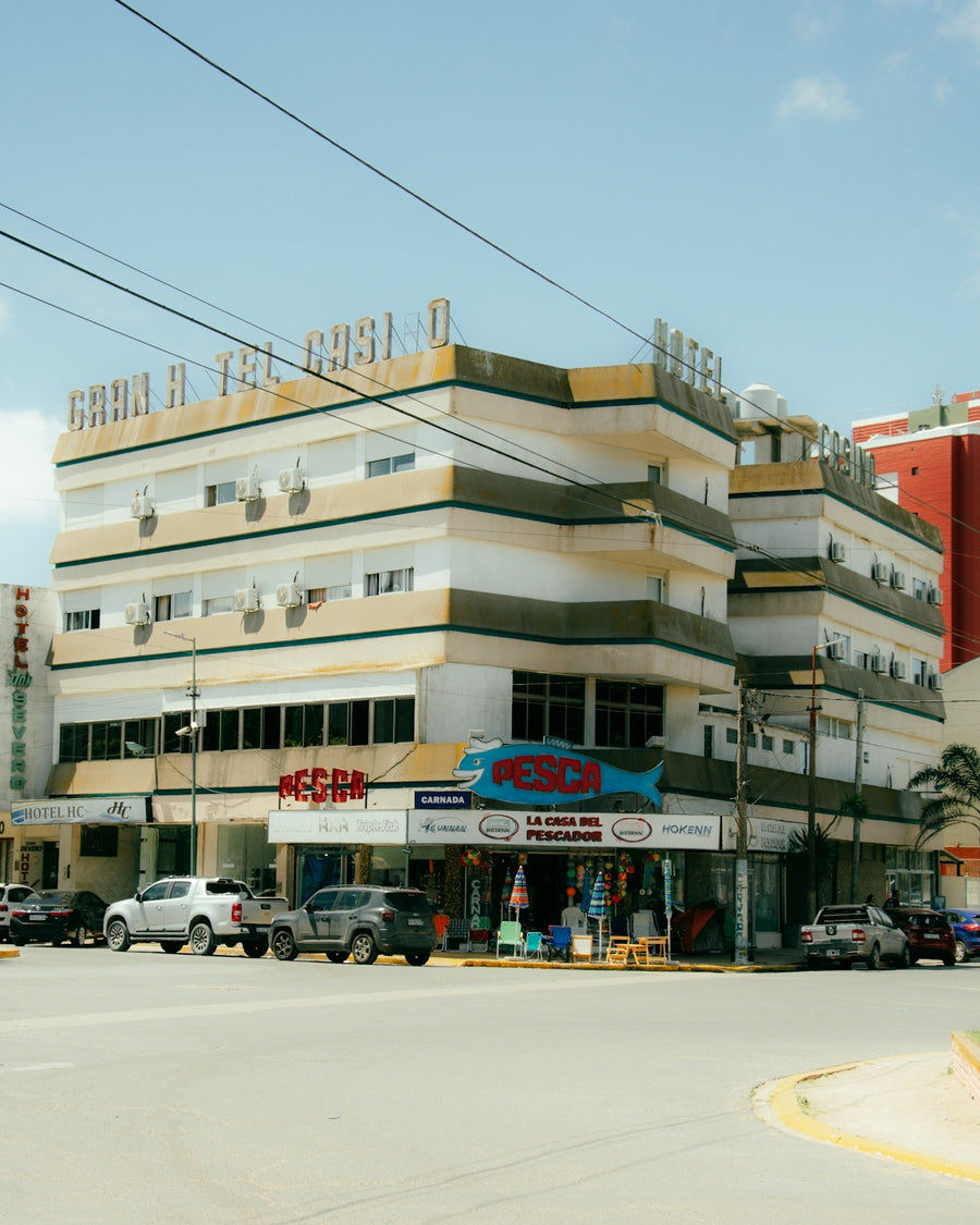 A street corner with cars parked in front of a building