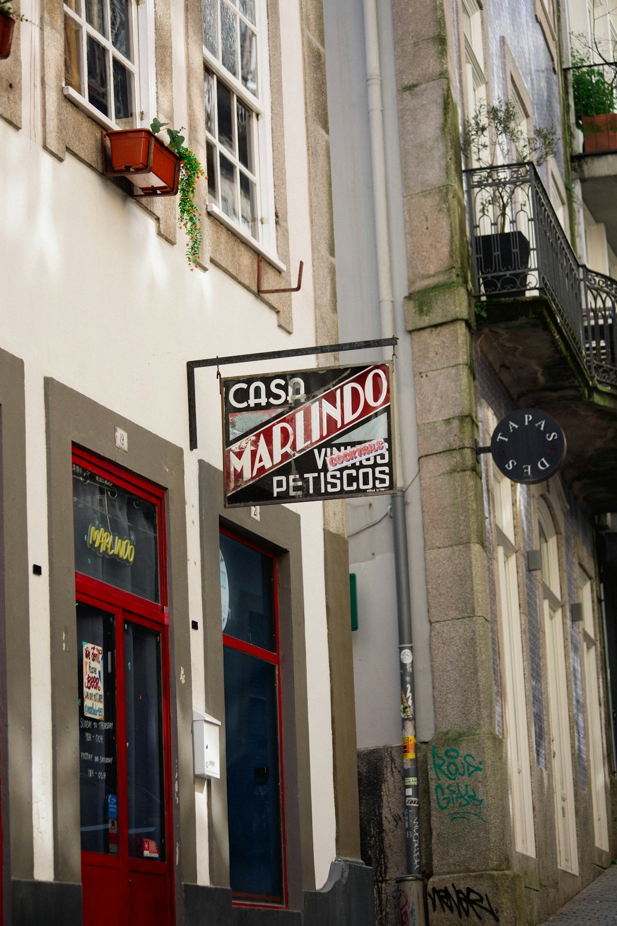 Building facade with a casa marlindo sign and red door.