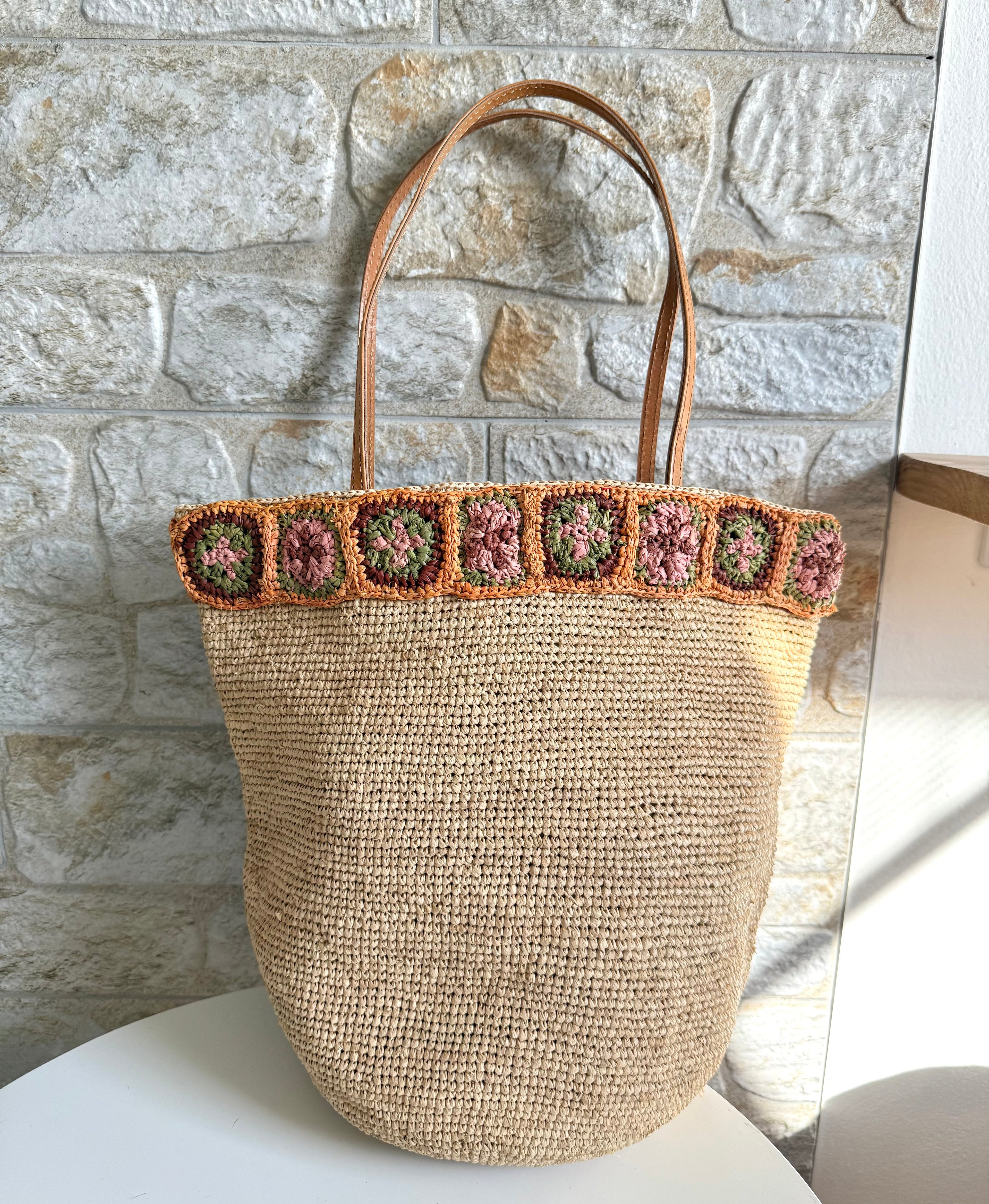 Flora - Borsa in rafia intrecciata fatta a mano con fiore in ambra all'uncinetto