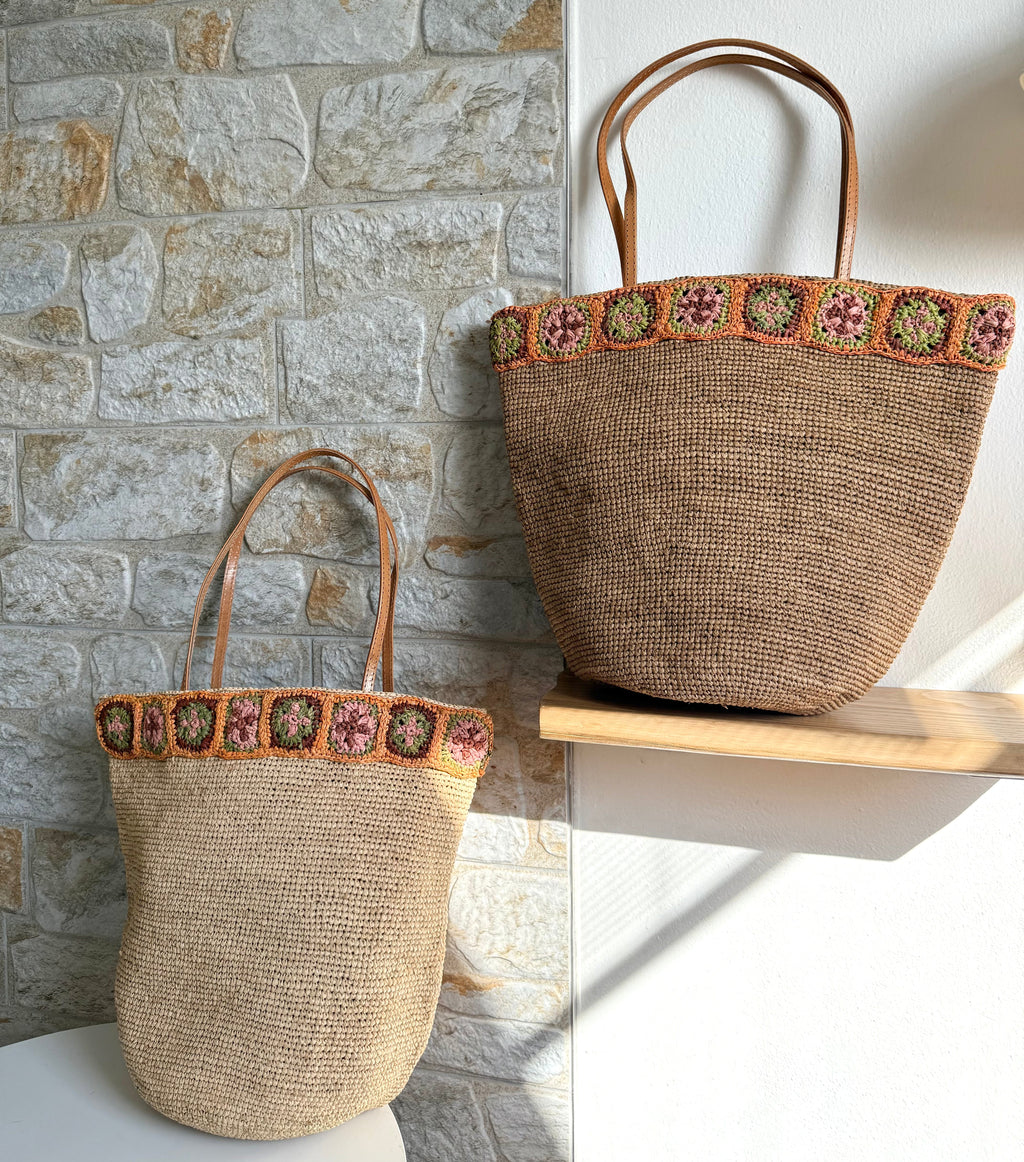 Flora - Borsa in rafia intrecciata fatta a mano con fiore in ambra all'uncinetto