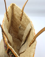 Flora - Borsa in rafia intrecciata fatta a mano con fiore in ambra all'uncinetto